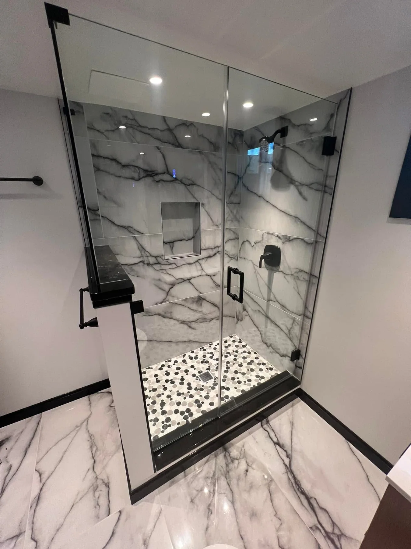 Custom marble-look walk-in shower with glass enclosure